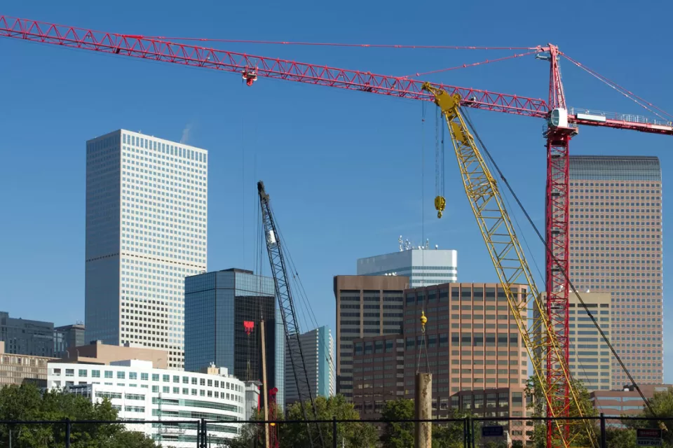 Construction crane in foreground, Denver skyline in background